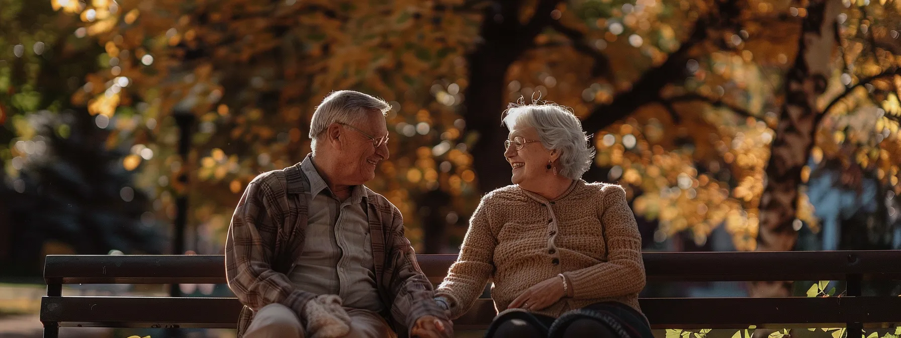 a senior couple smiling together, holding hands, while reviewing final expense insurance options on a sunny park bench.