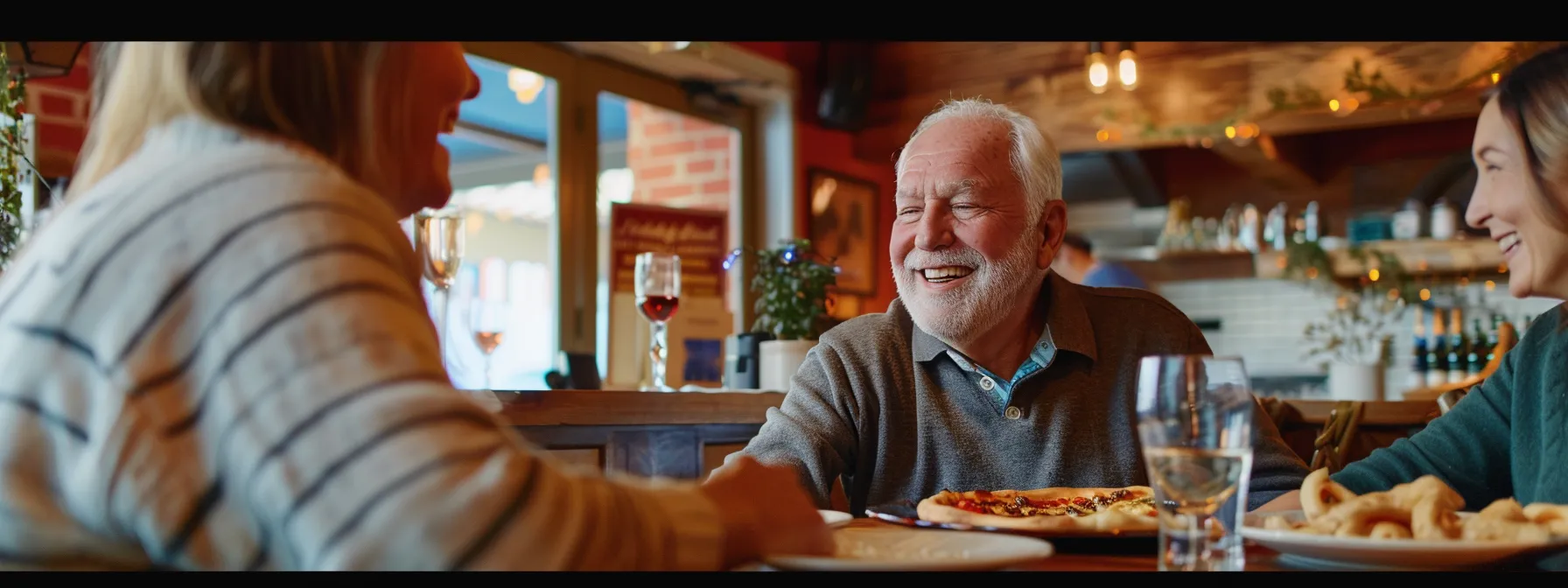 a senior couple smiling at a financial advisor as they discuss final expense insurance and review their policy together.