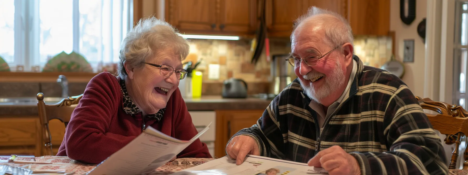 a senior couple smiling together while reviewing final expense insurance brochures at a cozy kitchen table.