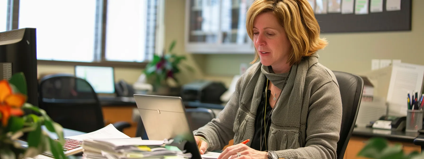 a woman sitting at a desk, surrounded by paperwork and a laptop, carefully reviewing a final expense insurance provider's financial stability, customer service processes, and policyholder reviews.